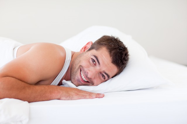Mann lächelnd im Bett